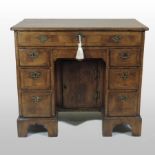 A George I style walnut, crossbanded and feather strung kneehole desk, of small proportions,