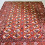 A Bokhara carpet, the central field with white and gold medallions on a red ground,