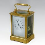 A large brass cased carriage clock, surmounted by a handle, the white enamel dial with Roman hours,