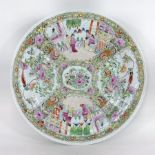 A Chinese Canton porcelain charger, reserved with panels of figures, on a floral ground,
