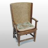 An early 20th century stained pine Orkney child's chair, with a bowed woven back and a rush seat,