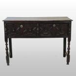 An 18th century oak dresser base, containing a pair of geometric moulded drawers,