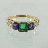 An unmarked emerald, diamond and sapphire ring,