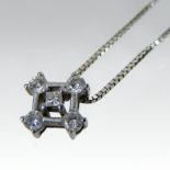 An 18 carat white gold and diamond set pendant, set with five stones, on a fine chain,