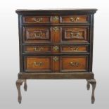 A Charles II style oak chest on stand, containing four geometric moulded drawers,