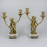 A pair of French style ormolu mounted marble figural two branch table candlesticks,