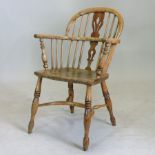 A 19th century ash and elm windsor style armchair, with a pierced splat and solid seat,
