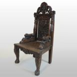 A 19th century carved oak throne chair, having a floral decorated back, with a pierced cresting,