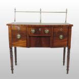 A Regency mahogany bow front sideboard, of small proportions, having a turned brass rail,