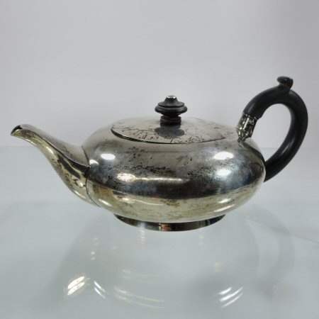 An Edwardian silver teapot, of compressed circular shape, with a hinged lid, by Asprey,