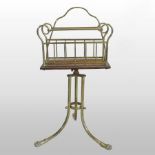 An early 20th century brass and oak magazine rack, on three splayed legs with lion paw feet,