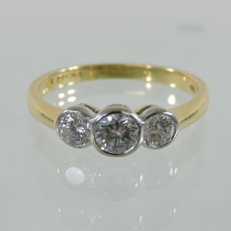 An 18 carat gold and platinum set three stone diamond ring,