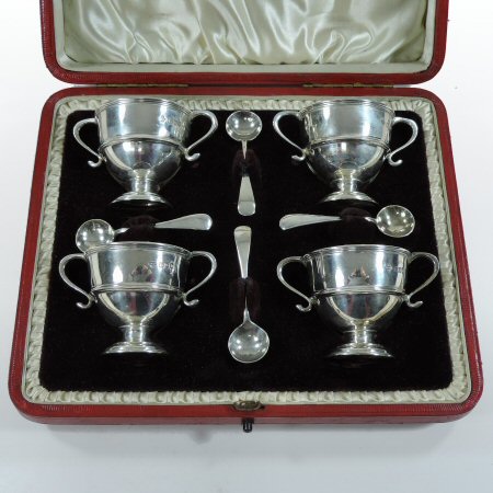 A set of four Victorian silver mustards, each in the form of a pedestal trophy cup,