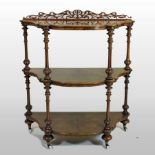 A Victorian burr walnut three tier whatnot, of serpentine shape, with a fret carved gallery back,