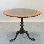 A 19th century mahogany and oak circular occasional table, with a hinged top, on a tripod base,