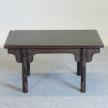 A Chinese ebonised and carved folding card table, decorated with bats,
