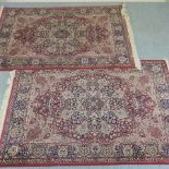 A pair of woollen Persian rugs, with a central medallion and floral decoration, on a red ground,