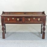 An 18th century oak dresser base, containing a pair of moulded frieze drawers, on carved legs,