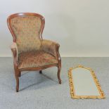 A Victorian style upholstered spoon back armchair, together with an arched gilt framed wall mirror,