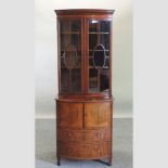 A mahogany and inlaid bow front display cabinet, with cupboards below,