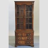 A reproduction mahogany astragal glazed cabinet, with brushing slide and drawers below,