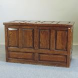 An 18th century style oak coffer, with a hinged lid and panelled front,