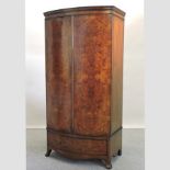 An early 20th century burr walnut bow front double wardrobe, on swept bracket feet,