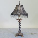 An ebonised and gilt painted table lamp, with a beaded shade,