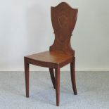 A George III carved mahogany hall chair,