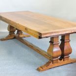 An unusually large light oak refectory style draw leaf dining table, having a plank top,