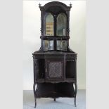 An Edwardian carved standing corner cabinet, with a mirrored back, on cabriole legs,
