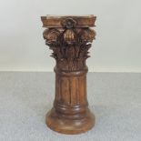 A carved hardwood pedestal, in the form of a column, relief decorated with scrolls and flowers,