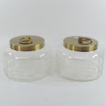 A pair of decorative cut glass jars, with brass covers,