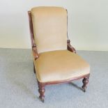 A Victorian mahogany and cream upholstered nursing chair