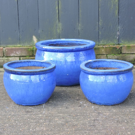 A set of three graduated blue glazed planters,