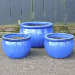 A set of three graduated blue glazed planters,