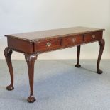 A carved rosewood side table, containing three frieze drawers, on claw and ball feet,