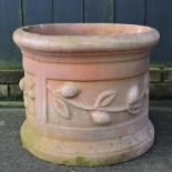 A large terracotta barrel shaped planter,