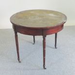 A Regency mahogany half-round folding card table, on ring turned legs,