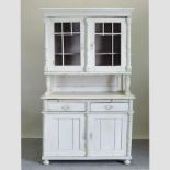 An antique white painted pine dresser, with a glazed upper section,