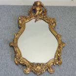 A 19th century gilt gesso cartouche wall mirror, with putti finial,