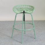 A green painted metal tractor seat bar stool