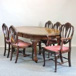 A 1920's walnut wind-out extending dining table, with an additional leaf, on claw and ball feet,