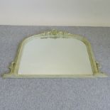 A carved and limed over mantle mirror,
