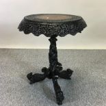 A 19th century Burmese heavily carved hardwood occasional table, on a tripod base,