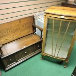 An oak monk's bench, together with a 1930's display cabinet,