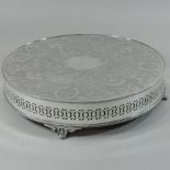 An engraved circular white metal cake stand,