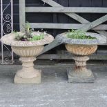 A pair of cream painted cast iron urns,