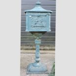 A Victorian style green painted metal postbox, on a pillar,