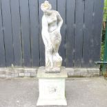 A reconstituted stone garden figure of a lady, standing on a pedestal base,